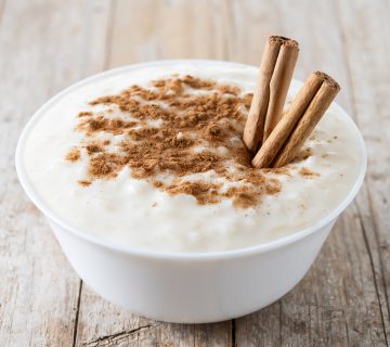 Arroz con leche  Rice pudding with cinnamon in bowl on wooden ta